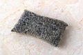 Old silver foam sponge for dishwashing on a kithen table. Metallized fiber foam sponge for dishes and housework. Purity and