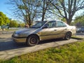 Old silver grey sedan car Nissan Almera parked