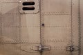 Old silver metal surface of the aircraft fuselage with rivets. Fuselage detail view. Airplane metallic fuselage detail