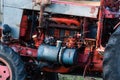 Old silver painted diesel tank on red vintage russian tractor engine visible wiring rust and oil drops on sunny autumn day in Royalty Free Stock Photo