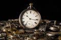 Old silver pocket watch on a pile of gears, gearwheels, cogwheels and metal bracelet on black isolated background Royalty Free Stock Photo