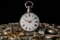 Old silver pocket watch on a pile of gears, gearwheels, cogwheels and metal bracelet on black isolated background Royalty Free Stock Photo