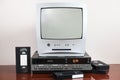 An old silver TV with built-in DVD player and a nearby vintage VCR from the 1980s, 1990s, 2000s. Royalty Free Stock Photo