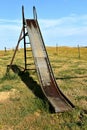 Old slippery-slide remains in a rural playground setting Royalty Free Stock Photo