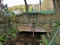 Old sluice gate across small river with iron work and pulleys