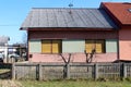 Old small attached suburban family house in need of restoration with faded facade and closed dilapidated window blinds Royalty Free Stock Photo