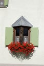 Balcony with windows and red geraniums - Zuoz village Engadine Switzerland Royalty Free Stock Photo