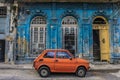 Old small car in front old blue house in La Havana, Cuba