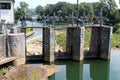 Old small dam made of stone and metal used to regulate and direct water to hydropower plant building