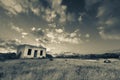 Old small deserted house in field with cloud sunset landscape ar Royalty Free Stock Photo