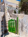 Old small green wooden door, wicket. Santorini street. Cyclades, Greece