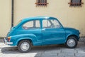 Old, small, Italian car: fiat 600 in perfect condition. Yellow background. Royalty Free Stock Photo