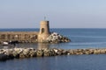 Old small lighthouse and stone wave breakers of Recco on a sunny summer day.