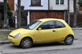 Old small rusty veteran yellow city car Ford KA first generation parked Royalty Free Stock Photo