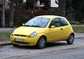 Old small rusty veteran yellow city car Ford KA first generation parked Royalty Free Stock Photo