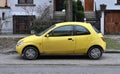 Old small rusty veteran yellow city car Ford KA first generation parked Royalty Free Stock Photo