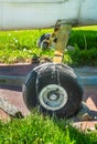 Old small single engine airplane wheel and wooden chocks on parking pad.