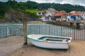 Old small fishing boat ,with the Asturian fishing village of Tazones (Spain) in the background. Royalty Free Stock Photo