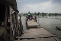 Old small wooden ferry with foot and bikes passengers starts crossing the Mekong river in its delta in Southern Vietnam