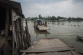 Old small wooden ferry with foot and bikes passengers starts crossing the Mekong river in its delta in Southern Vietnam