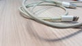 Old smart phone charger wire on laminate floor. Royalty Free Stock Photo