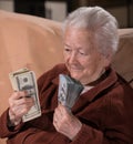 Old smiling gray-haired woman holding dollar cash money Royalty Free Stock Photo