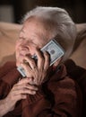 Old smiling gray-haired woman holding dollar cash money Royalty Free Stock Photo