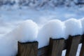 Old snowy fence in village in the winter