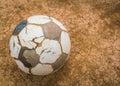Old soccer ball on Dry and cracked ground texture . Royalty Free Stock Photo