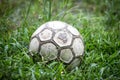 Old soccer ball in the grass on a rainy