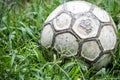 Old soccer ball in the grass on a rainy