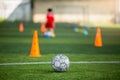 Old soccer ball on green artificial turf with blurry soccer team training Royalty Free Stock Photo