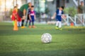 Old soccer ball on green artificial turf with blurry soccer team training Royalty Free Stock Photo