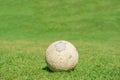 Old soccer ball on green grass of soccer field Royalty Free Stock Photo