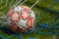 old soccer ball in the net on the background of grass soccer field. Summer sunny day Royalty Free Stock Photo