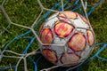 old soccer ball in the net on the background of grass soccer field. Summer sunny day Royalty Free Stock Photo