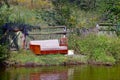 Old sofa near a wooden fence in the grass on the lake shore