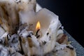 Old soiled big candles on a wooden black table. An old method of lighting rooms