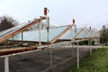 Old solar panels on abandoned parking lot with rusted pipes and metal support