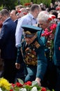 Old soldier come put flowers to Eternal Flame during celebration Victory Day in commemoration of Soviet soldiers