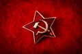 Old Soviet badge with the red star, a sickle and a hammer reminiscent of the cold war era worn by the soldiers of the red army on Royalty Free Stock Photo