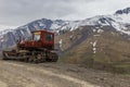 Old Soviet caterpillar tractor in the background of snow-capped Royalty Free Stock Photo