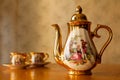 Old soviet gilded porcelain teapot and two cups. Royalty Free Stock Photo