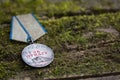 The Old Soviet Medal with written in Russian For Bravery, Second World War, natural moss background, Victory Day May 9