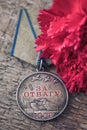 The Old Soviet Medal For Bravery of the Second World War with a red carnation, Victory Day May 9 postcard concept Royalty Free Stock Photo