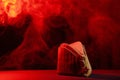 An old Soviet military cap of khaki on a black background with red light and smoke. Symbolism May 9