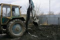 An old Soviet tractor digs and loads waste stone processing