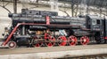 Old Soviet vintage black retro train with a red star at the railway station in Lviv produces steam from the pipes and the passeng Royalty Free Stock Photo