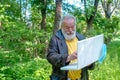 Old Spanish man with a white beard and happy face learning to use a computer standing outside