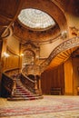 Old spiral wooden staircase with vintage railing indoors. luxury carved wood interior in the hall of an aristocratic palace. rare Royalty Free Stock Photo